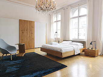 Exklusives Schlafzimmer von Team 7, mit einem großen Schwebetüren Kleiderschrank, abgesetzt mit Glas und dem Handwerklichen tollen Bett Nox. 